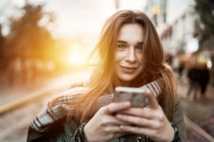 Woman Looking At Camera With Phone